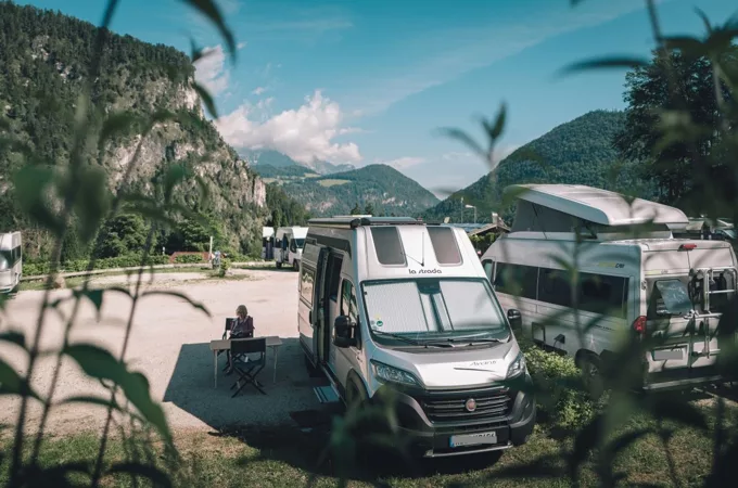 Several motorhomes at a rest area in the mountains.